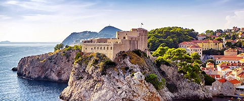 Malerische Küstenfestung in Dubrovnik, umgeben von azurblauem Meer und historischer Architektur.