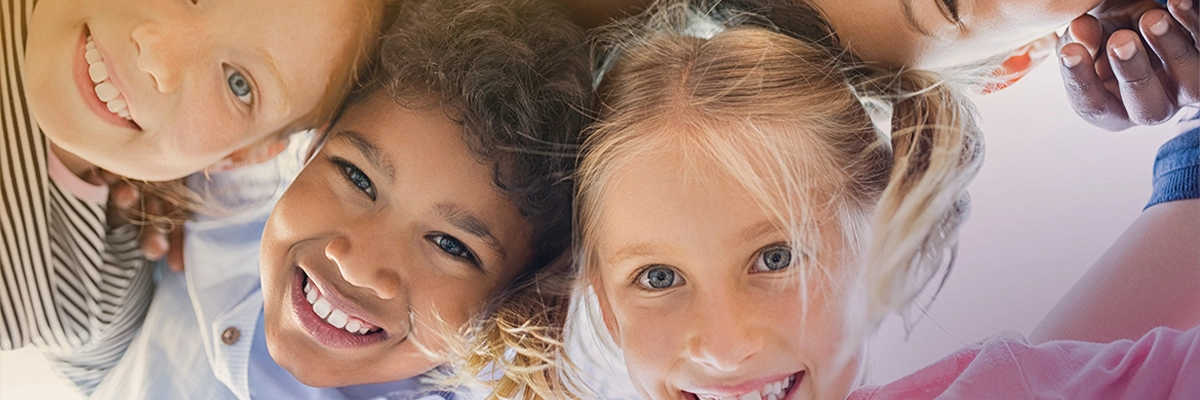 Fröhliche Kinder lächeln in die Kamera, Vielfalt und Freude in der Gemeinschaft.