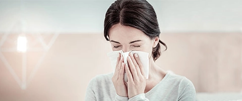 Frau niest in Taschentuch, gesund bleiben, Allergiehilfe.