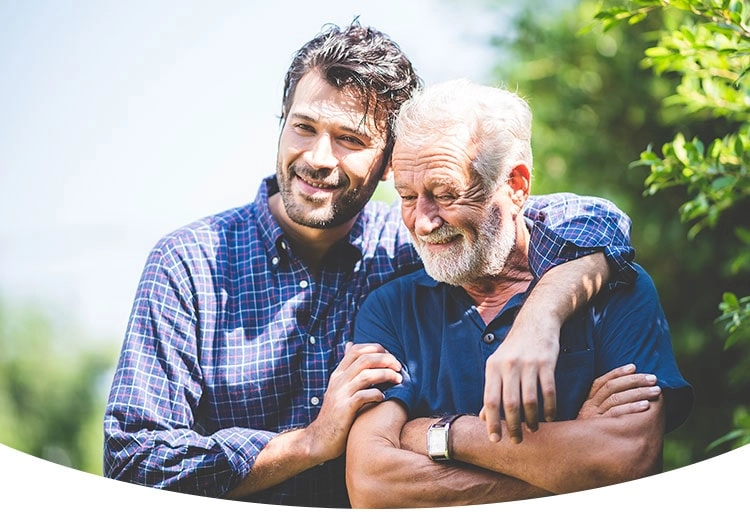 Zwei Generationen vereint: Vater und Sohn genießen sonnige Momente im Garten.