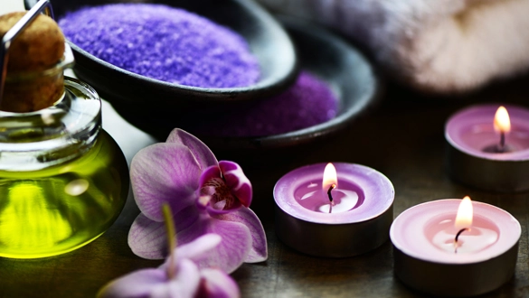 Luxuriöses Spa-Erlebnis: Duftkerzen, Orchideen und Lavendel für Entspannung.