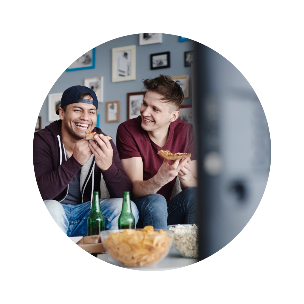 Freunde auf Sofa mit optimalem Sitzabstand zum Fernseher