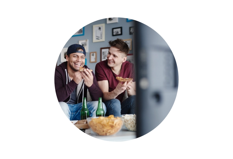 Freunde auf Sofa mit optimalem Sitzabstand zum Fernseher