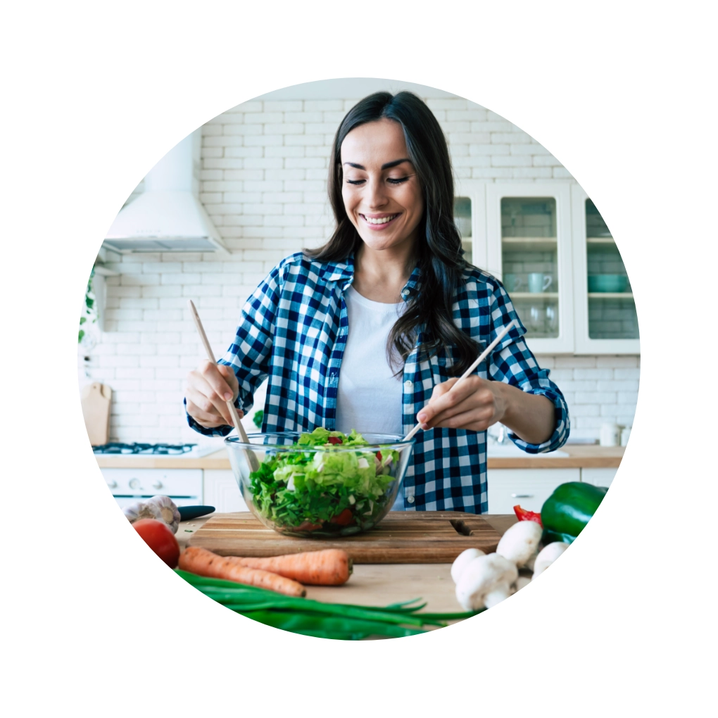 Fröhliche Frau bereitet frischen Salat in moderner Küche zu. Gesundes Kochen erleben!