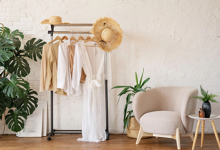 Elegante Sommermode im stilvollen Interieur mit Pflanzen und gemütlichem Sessel.