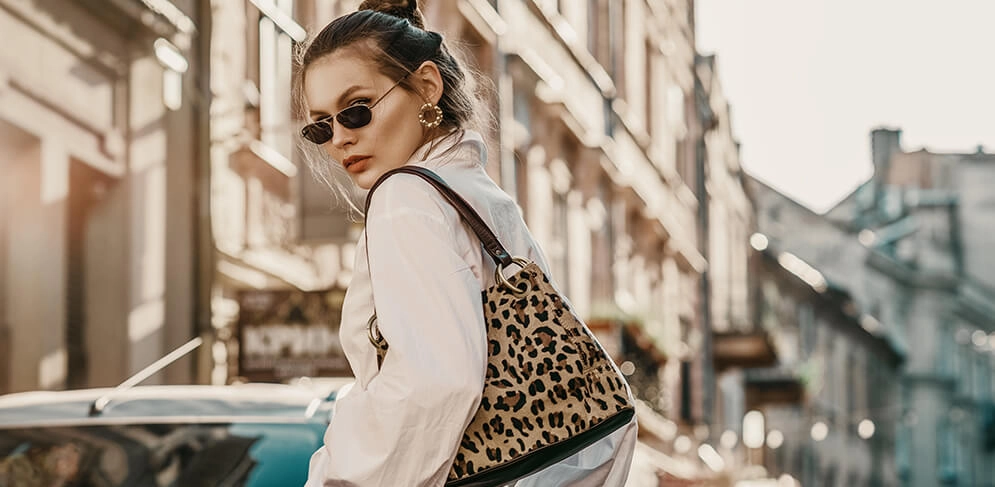 Frau trägt eine Tasche mit Leoprint in Kombination mit einem schlichten Outfit