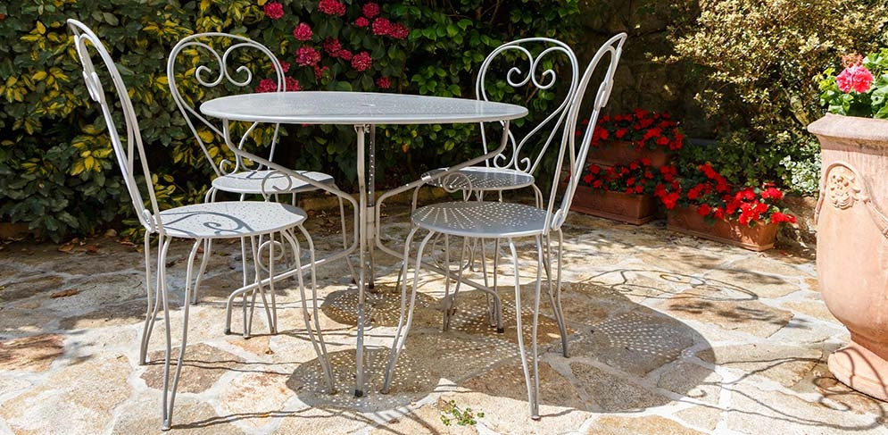 Ein Set aus Metall-Gartenmöbeln steht in der Sonne 