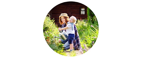 Mutter und Kind genießen Gartenzeit im Sommer, Naturerlebnis pur.