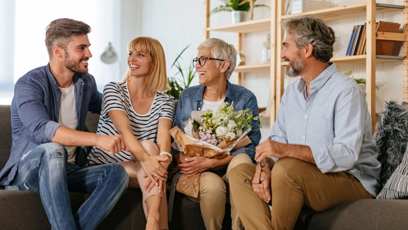 Ein Paar besucht gemeinsam die Schwiegereltern und verschenkt Blumen