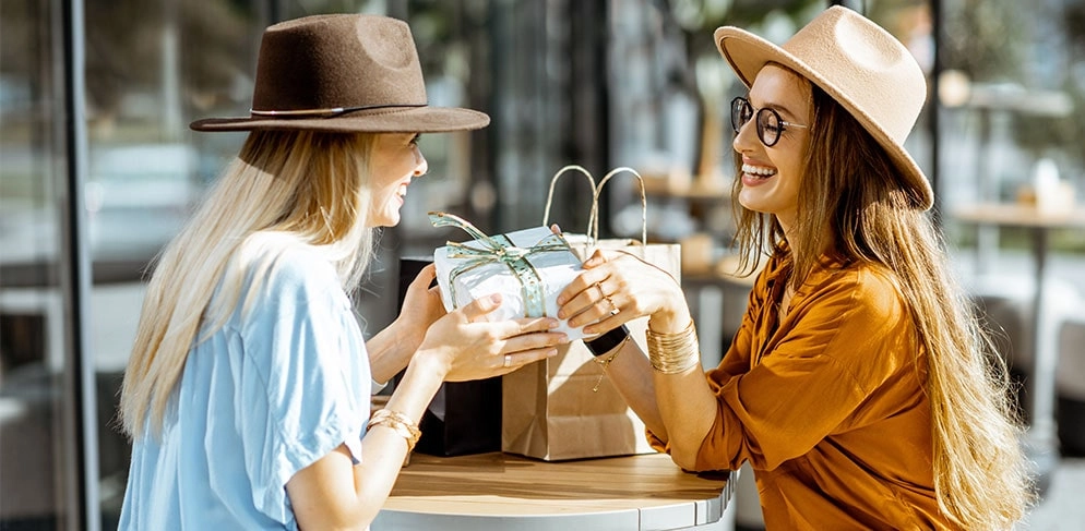 Zwei junge Frauen tauschen Geschenke untereinander aus