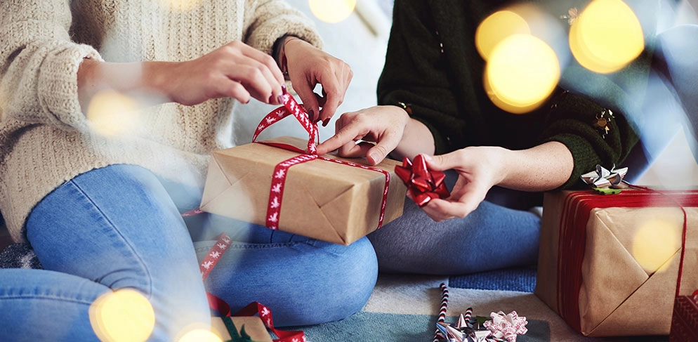 Zwei Frauen packen gemeinsam Geschenke ein