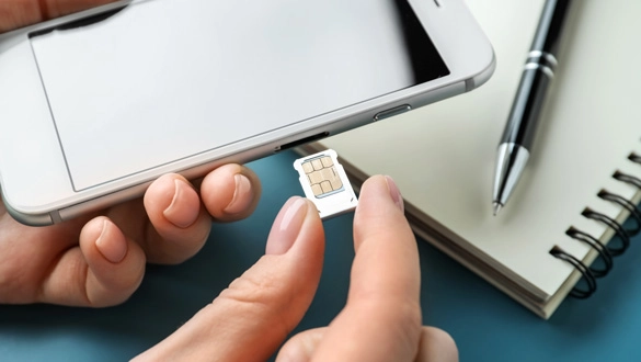 Ein Frau hat einen neuen Handyvertrag und schiebt ihr neue SIM-Karte in ihr Smartphone
