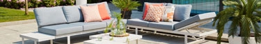 Moderne Outdoor-Lounge mit stilvollen Möbeln und Pflanzen, ideal für Entspannung im Freien.