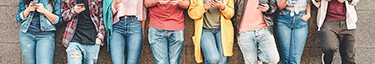 Junge Menschen in Freizeitkleidung nutzen Smartphones, urbaner Lifestyle.