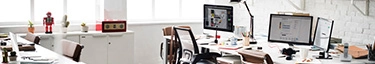 Modernes, lichtdurchflutetes Büro mit stilvollen Arbeitsplätzen und Technologie.