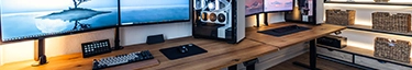 Moderner, eleganter Arbeitsplatz mit drei Monitoren und stilvollem PC-Setup.
