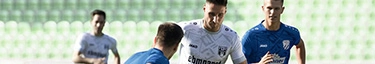 Fußballspieler im intensiven Training auf grünem Spielfeld, dynamische Team-Action.