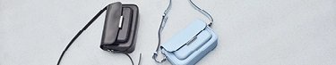 Elegante schwarze und blaue Handtaschen auf stilvollem Hintergrund.