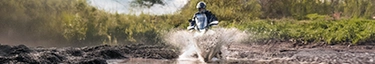 Abenteuerliche Motorradfahrt durch schlammiges Gelände, Freiheit und Natur erleben.
