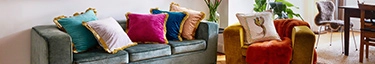 Luxuriöses Wohnzimmer mit stilvollen, bunten Kissen auf einem eleganten Sofa.