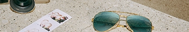 Stylische Sonnenbrille und Kamera auf modernem Betonhintergrund für Sommerabenteuer.