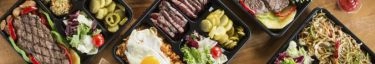 Hochwertige Grillgerichte in stilvollen Bento-Boxen, ideal für Catering und Events.