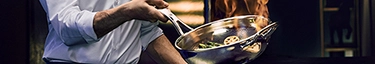 Koch in Aktion: Gourmetgericht flambiert in eleganter Küche. Perfektion trifft Leidenschaft.