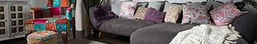 Bunte, gemütliche Wohnzimmer-Einrichtung mit stilvollem Sofa und farbenfrohem Sessel.